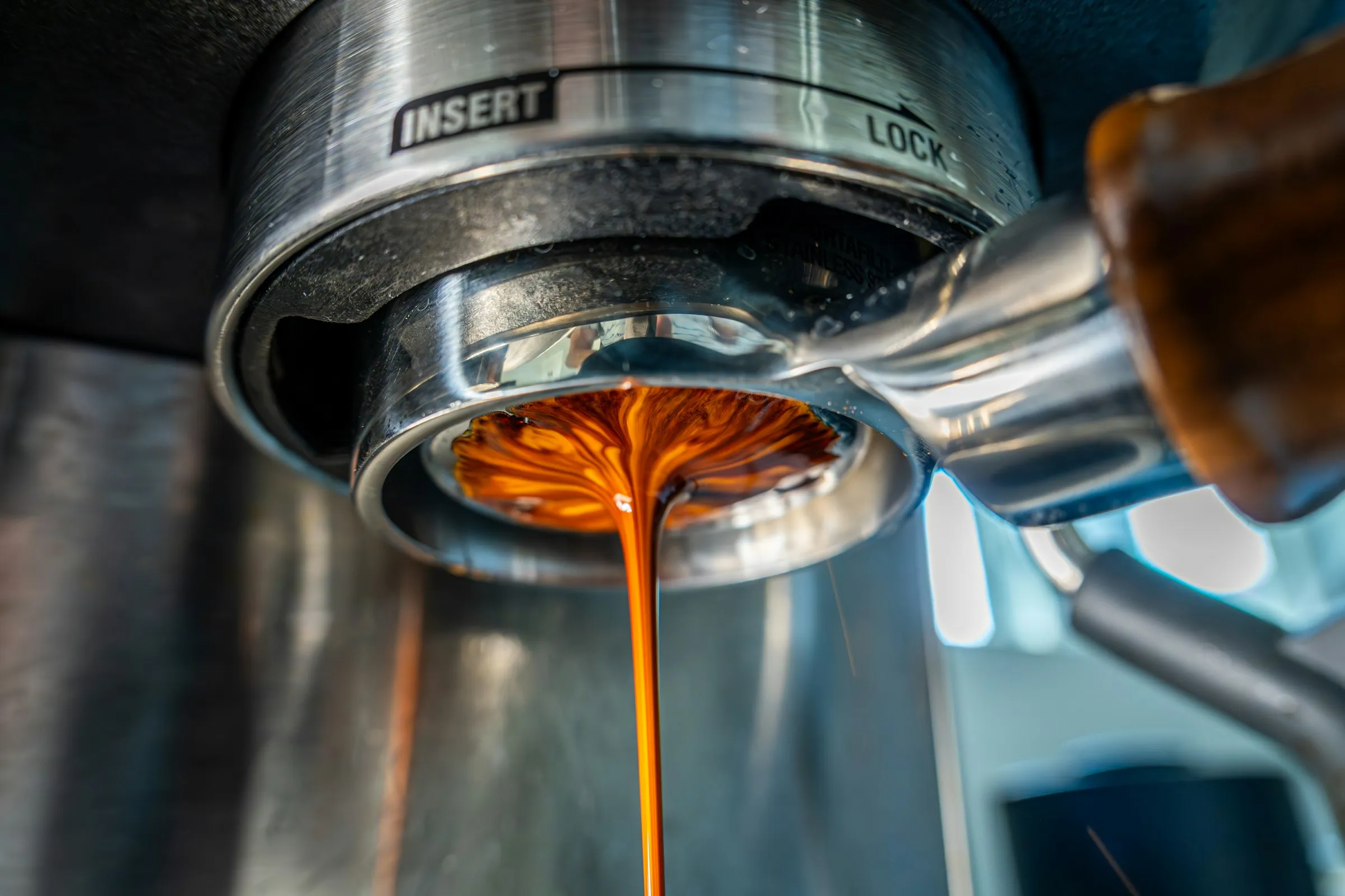 Espresso pouring from a portafilter into a cup on a home machine