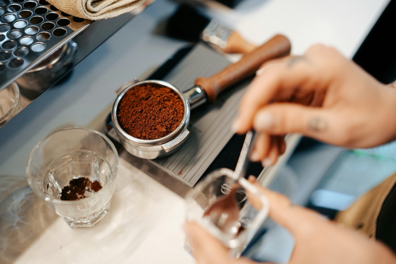 Freshly ground coffee dosed into a portafilter on a scale